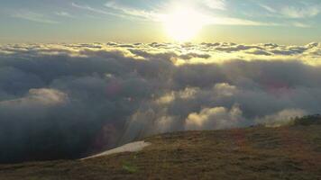 Young woman is running on mountain plateau above pink clouds at sunrise video