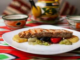 Salmon steak on a pillow of stewed vegetables. Asian style photo