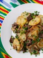 Fried potatoes with pieces of meat. Asian style photo