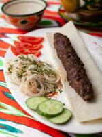 beef and lamb shashlik grilled meat, minced meat. Served with vegetables, pickled onions, lavash bread photo