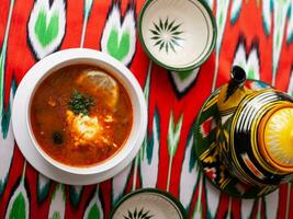 Solyanka. Meat soup made from meat, smoked meats, olives and lemon, served with sour cream. East style photo