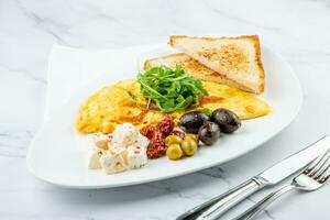 Breakfast of eggs with meat, herbs and drops of sauce with bread in a round plate side view photo