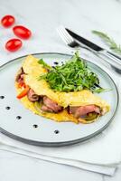 Breakfast of eggs with meat, herbs and drops of sauce in a round plate side view photo