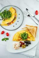 Breakfast of eggs with meat, herbs and drops of sauce with bread in a round plate top view photo