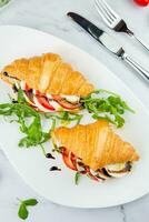 croissants with cheese, vegetables, cherry tomatoes and herbs top view photo