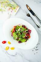 salad of greens, lettuce leaves, cucumbers, pink onions, top view photo