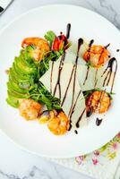 shrimp with avocado slices and arugula with teriyaki sauce top view photo