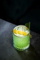 lime coctail with pineapple pieces and cinnamon side view photo