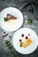 white sponge cake with drops of syrup, mint and wild berries on a round plate top veiw photo
