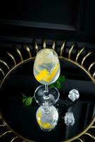 side view of transparent carbonated cocktail with lemon and ice photo