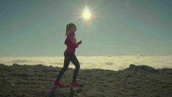 Woman in sunglasses is jogging in mountains. Instagram look. Slow motion video