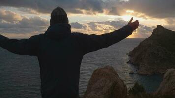 silhouette di uomo con sollevato mani in piedi godendo tramonto video