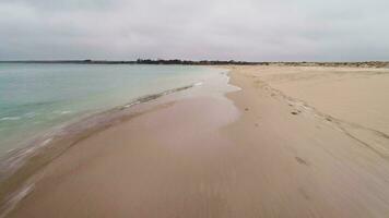 Extremely low angle fast drone flying forward over calm sea coastline. video