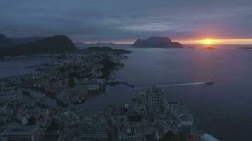 Alesund pueblo en Noruega a vistoso puesta de sol con nublado cielo. aéreo vista. zumbido es volador adelante y ascendente video