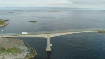 camper auto reist Aan Storseisundet brug. atlantic oceaan weg in Noorwegen Bij zonnig zomer dag. antenne visie. dar is vliegend zijwaarts video
