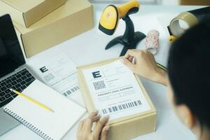 Young business owner putting shipping label on parcel. photo