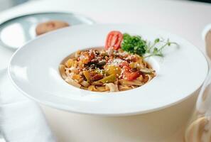 udon noodles with sesame seeds and herbs in a white plate side view photo