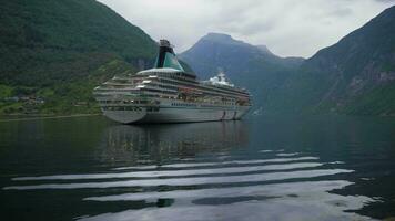 groot luxe reis schip is afgemeerd in geiranger fjord Bij zomer dag. groen bergen. Noorwegen video