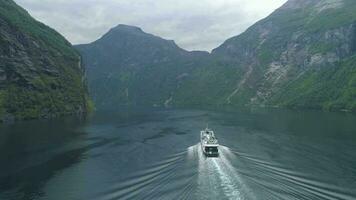 traversier navire dans geiranger fjord dans été journée. vert montagnes. Norvège. aérien voir. drone orbites autour video