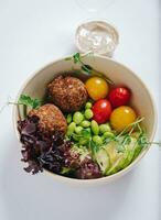 bowl in Chinese style.meatballs with beans, herbs, cherry tomatoes and sauce in a bowl photo