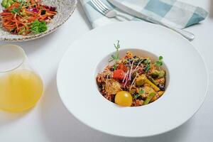vegetable stew with potatoes, tomatoes and herbs with sauce in a deep plate side view photo