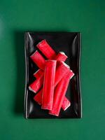 crab sticks on a green background. View from above. Chinese cuisine, ingredient for hotpot photo