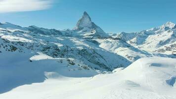 Blau Matterhorn Berg und Stehen Wanderer im Winter Tag. schweizerisch Alpen, Schweiz. niedrig Niveau Flug Über Mann. Antenne Sicht. Drohne fliegt rückwärts video