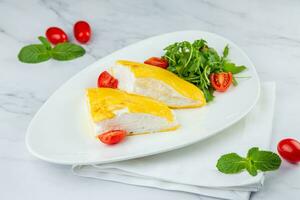 French tall omelette with arugula and cherry tomatoes side view photo