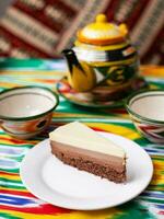 dessert cheesecake three chocolates in an oriental style with a teapot and a cup for tea. photo