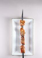 delicious fresh chicken shashlik on a white plate. View from above. Chinese cuisine, ingredient for hotpot photo