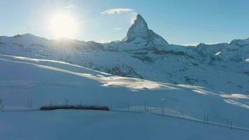 matter fjäll, gornergrat tåg och Sol i vinter- på solnedgång. schweiz. antenn se. Drönare flugor sidled video