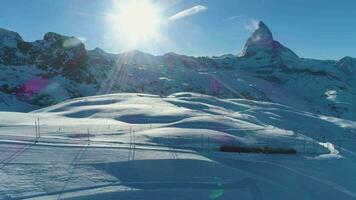 matterhorn berg en gornergrat trein in zonnig winter dag. Zwitsers Alpen. Zwitserland. antenne visie. dar vliegt zijwaarts, camera kantelt omhoog video