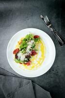 salad with red cabbage, meat, cheese and herbs with sauce in a round plate top view photo