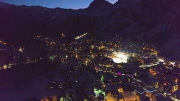 Zermatt villaggio e Cervino montagna a notte. svizzero Alpi, Svizzera. aereo Visualizza. svelare sparo. fuco mosche inoltrare, telecamera si inclina su video