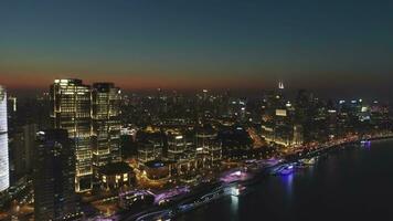 Silhouettes of people on the top of rock at twilight. Illuminated City Skyline in Smog. Aerial View. Drone is Flying Backward and Upward. Establishing shot video