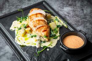 baked chicken fillet in creamy sauce with herbs side view photo