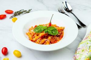 carbonara pasta with cheese and herbs on top on a white plate side view photo