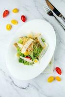 salad with quail eggs, cherry tomatoes, lettuce and breadcrumbs, top view photo