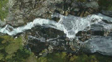 vattenfall, stenar och grön träd i Norge. antenn vertikal top-down se. Drönare är flygande sidled video