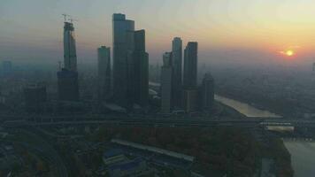 grattes ciels de Moscou ville affaires centre et ville horizon à été ou l'automne brumeux lever du soleil. Russie. aérien voir. drone est en volant avant, caméra est basculant en haut video