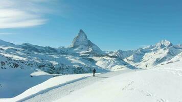 bleu Matterhorn Montagne dans hiver journée et promeneur homme. Suisse Alpes, Suisse. aérien voir. drone est en orbite video