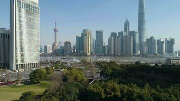 Shanghai, Kina - januari 12 2018 shanghai horisont och huangpu flod på solig dag. lujiazui finansiell distrikt. antenn se. flygande framåt- över grön parkera. upprättande skott video