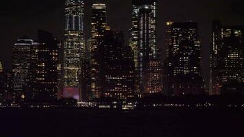 Manhattan stedelijk horizon Bij nacht. nieuw york stad. visie van de water. camera kantelt omhoog. medium schot video