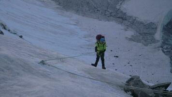 alpinista homem dentro grampos é usando Jumar em fixo corda para subir em íngreme montanha passar. lento movimento video