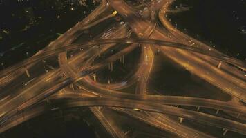 illuminé complexe route jonction et voitures circulation à nuit. drone est en orbite autour. aérien temps laps dans mouvement. hyperlapse video