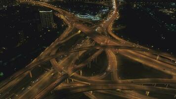 Illuminated Complex Road Junction and Cars Traffic at Night. Drone is Flying Forward, Camera is Tilting Down. Aerial Vertical View video