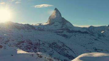 Matterhorn Mountain at Sunset in Winter. Snowy Swiss Alps. Switzerland. Aerial View. Drone Flies Backwards at Low Level video