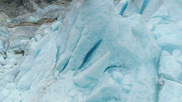 azul nigardsbreen glaciar es brazo de jostedalsbreen glaciar - el mas grande en Europa. Noruega. hielo bloques aéreo de cerca vista. zumbido es orbital alrededor, cámara es inclinación abajo video