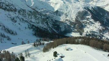Matterhorn Mountain and Skiers on Piste in Winter Day. Swiss Alps, Switzerland. Aerial View. Drone Flies Sideways, Camera Tilts Up video