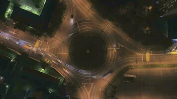 Illuminated Roundabout in the City and Cars Traffic at Night. Round Crossroad. Aerial Time Lapse video